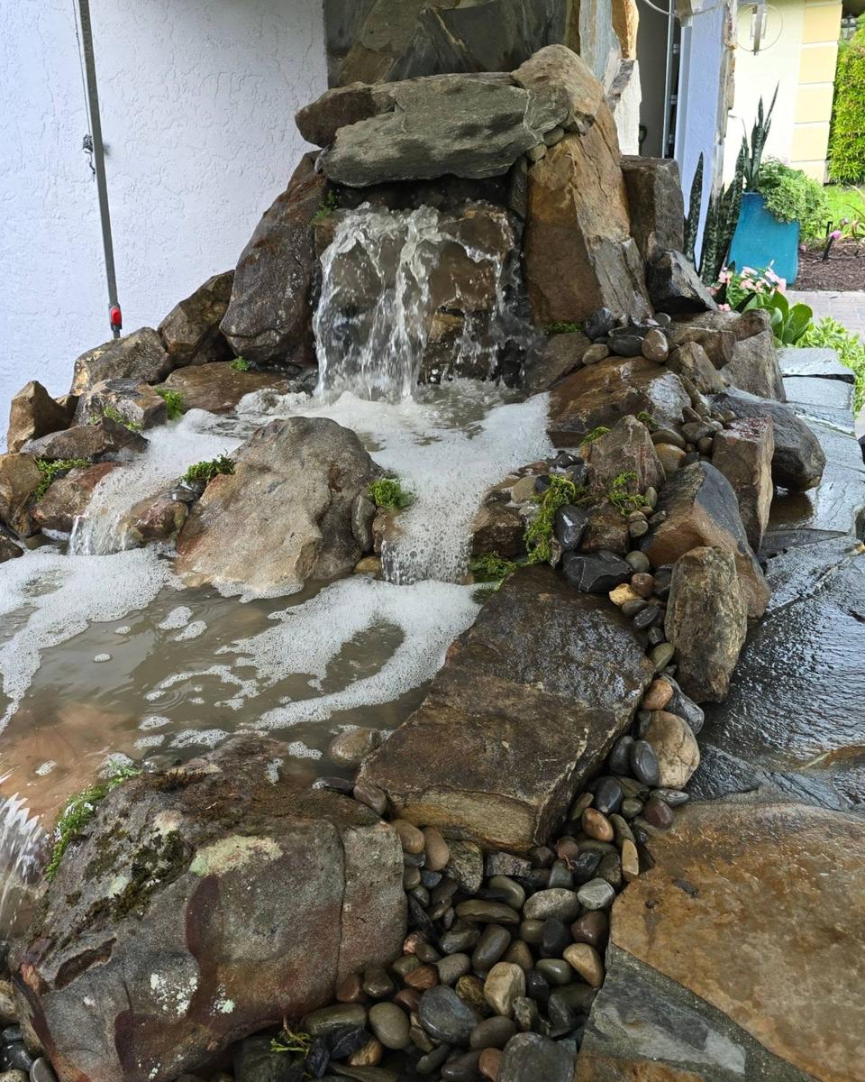 Close view of a pondless waterfall cascading down fieldstone boulders
