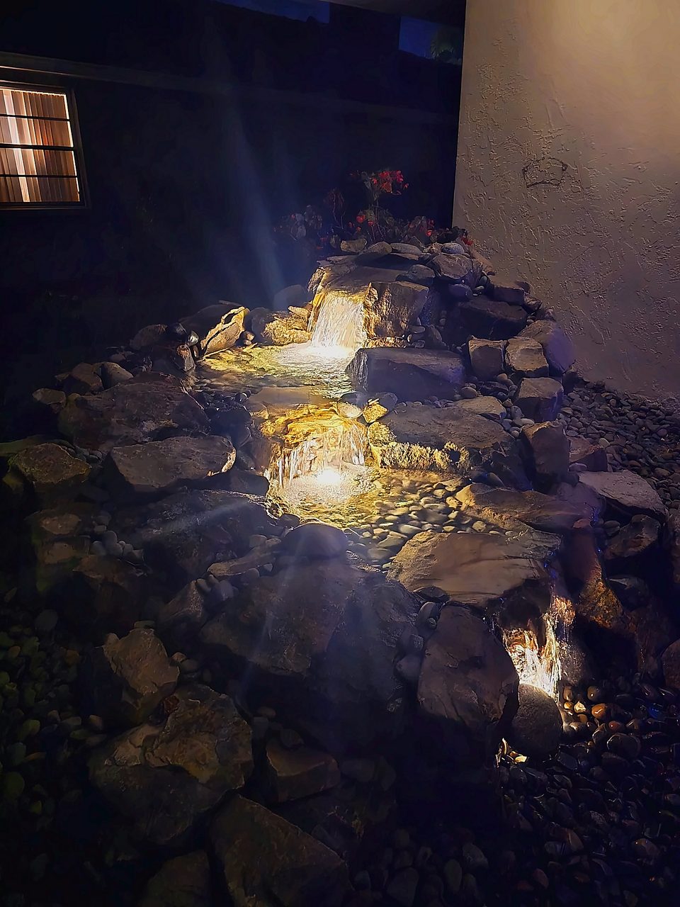 Oasis waterfall glowing at night with underwater lights